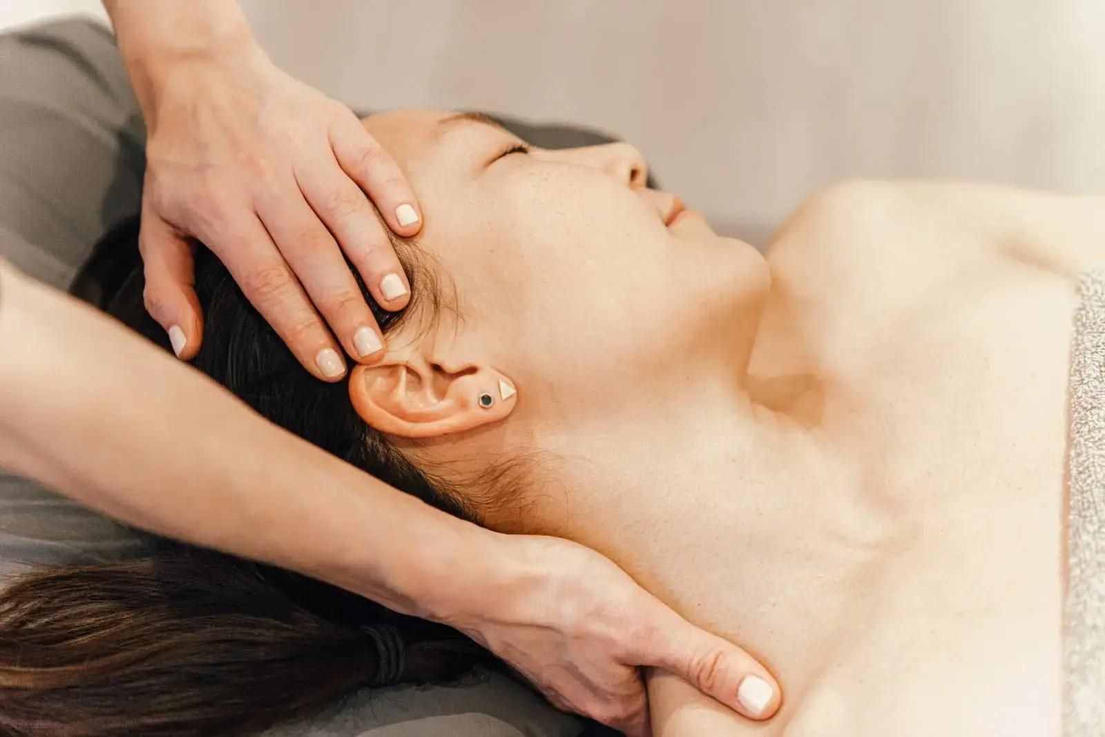 Therapist performing a buccal massage to enhance facial contour and reduce tension.