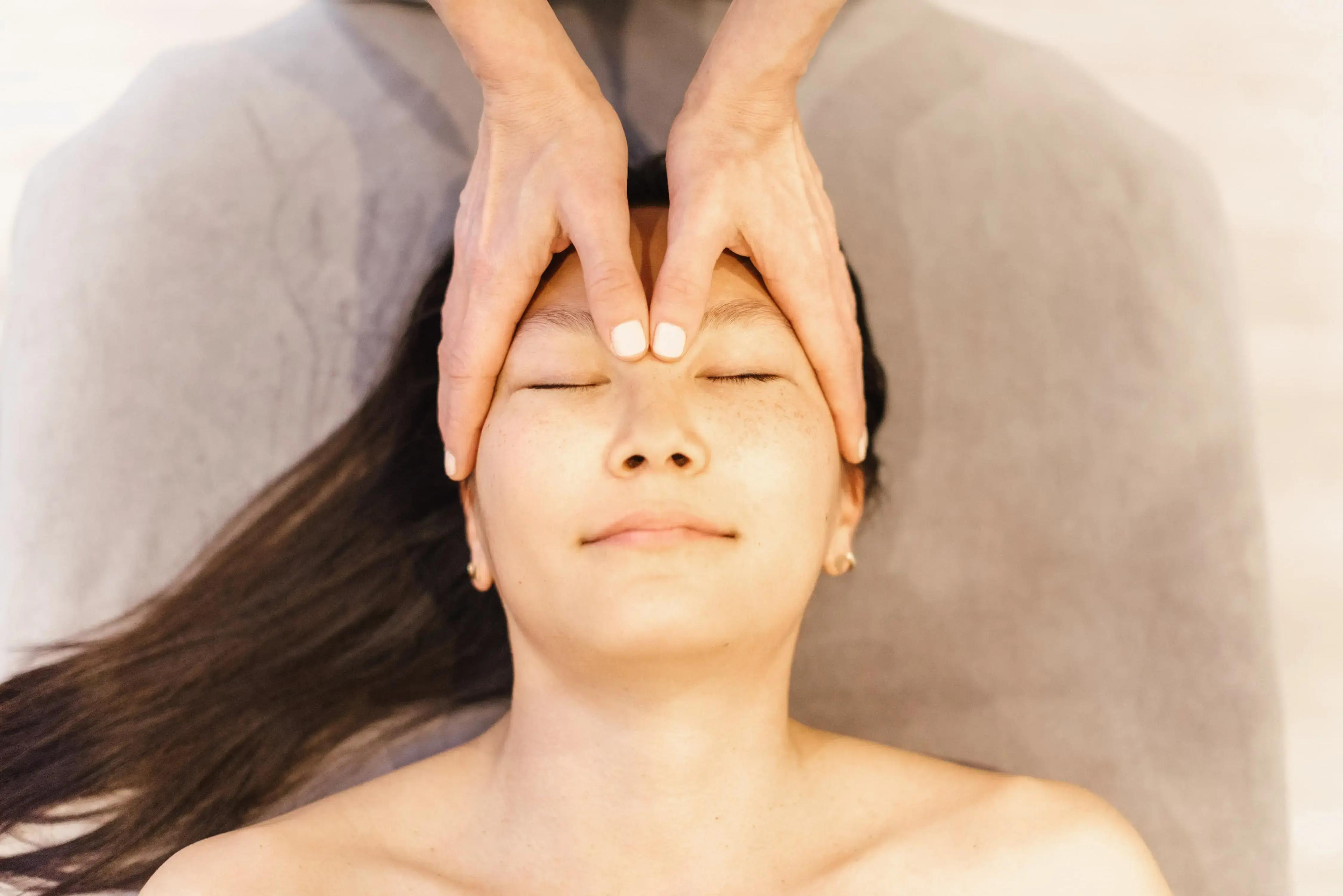 Therapist performing a soothing head massage to relieve tension.