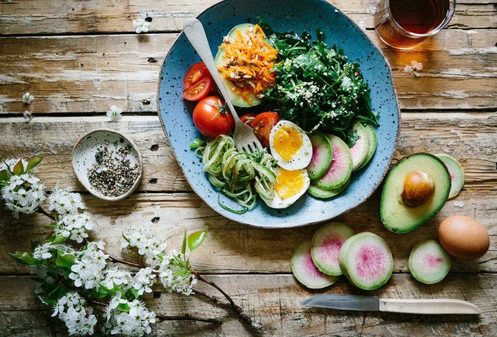 Healthy Ingredients on a Chopping Board: Avocado, Eggs, and Fresh Vegetables